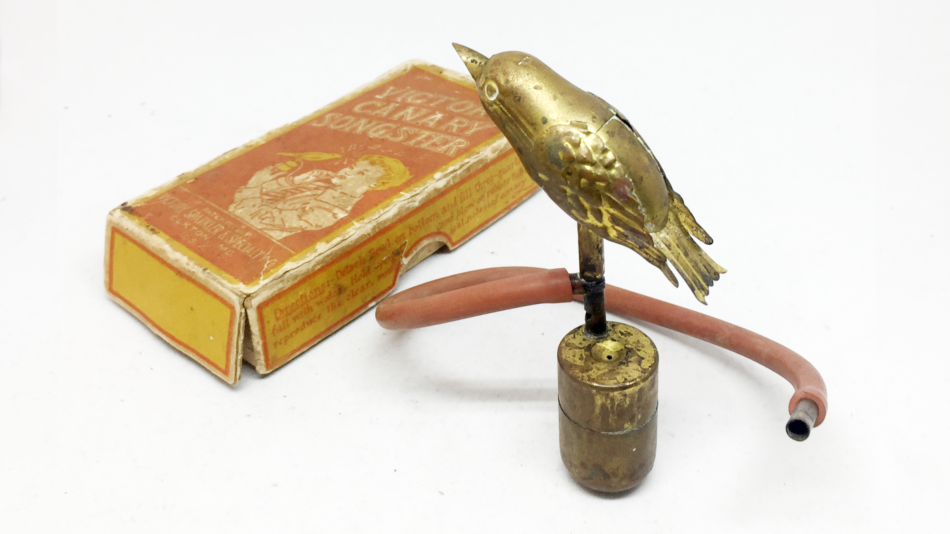 Ein antiker Blechspielzeugvogel aus Messing und passende Kartonverpackung